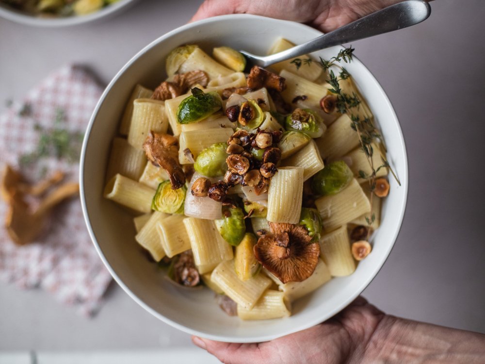 Rigatoni pasta with mushrooms and hazelnuts, in a bowl ready to eat