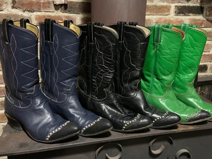 row of 3 pairs of western boots on wood stove