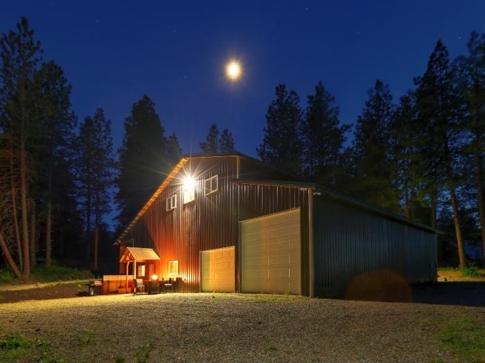beautiful farm home illuminated with outdoor lighting and the full moon