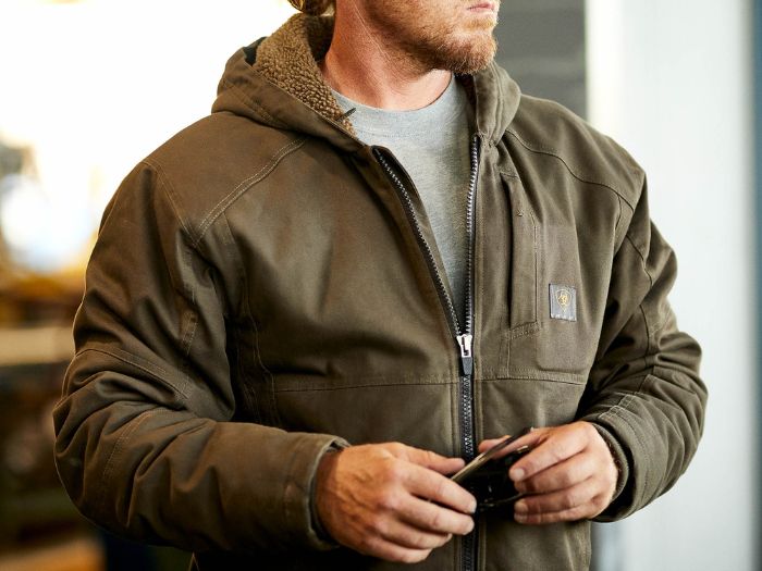 A man wearing a jacket made of waterresistant workwear fabric from Wilco Farm Store.