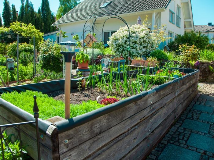 A home with a backyard homestead and rasied vegetable beds.