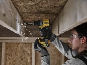 A woman using a DeWalt drill for a construction project.