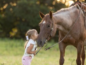 A little girl kisses her first horse.